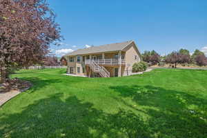 Back of property featuring stucco siding, stairs, and a wooden deck