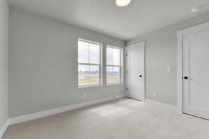 Unfurnished bedroom featuring carpet floors, a textured ceiling, and a closet