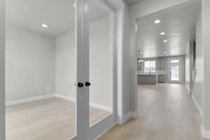 Corridor featuring light wood-style flooring, recessed lighting, a chandelier, and a textured ceiling