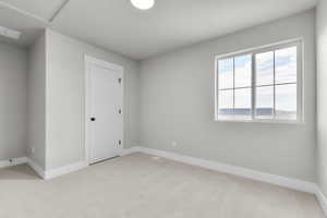 Unfurnished bedroom with light carpet and a textured ceiling