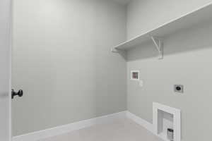 Washroom with electric dryer hookup, hookup for a washing machine, and light tile patterned floors