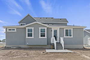 Back of property featuring roof with shingles