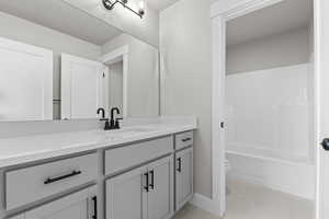 Full bathroom with vanity, light tile patterned floors, and shower / tub combination