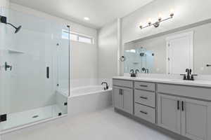 Bathroom with a shower stall, a garden tub, double vanity, and light tile patterned floors