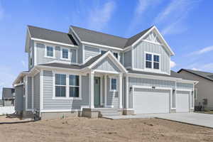 View of front of home with board and batten siding, a shingled roof, driveway, and a garage