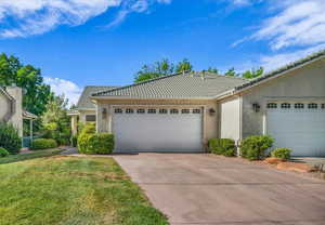 Single story home featuring a tile roof, stucco siding, concrete driveway, and a garage