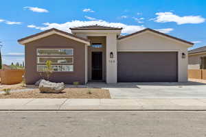 View of front of property with an attached garage, stucco siding, concrete driveway, and a tiled roof
