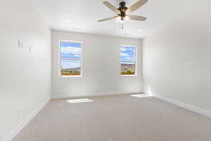 Carpeted spare room with a ceiling fan and recessed lighting