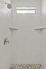 Bathroom with tiled shower and plenty of natural light