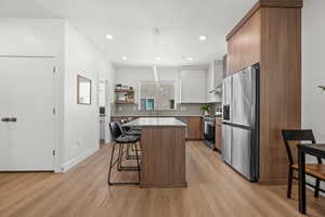 Oversized island for living, entertaining, and ideal for folding laundry! Don't forget to gaze upon the gorgeous waterproof LVP flooring throughout  the main level.