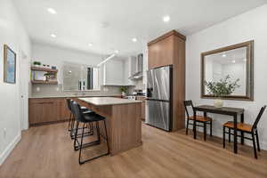 European-style soft-close cabinets in natural wood and Drift of Mist.