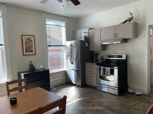 Kitchen featuring appliances with stainless steel finishes, under cabinet range hood, a ceiling fan, and a textured ceiling