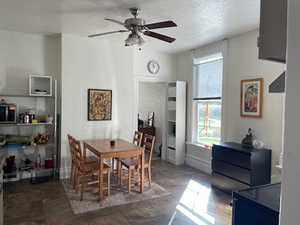 Dining room featuring ceiling fan and a textured ceiling