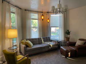 Carpeted living area featuring a chandelier