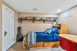 Bedroom featuring carpet flooring and a textured ceiling