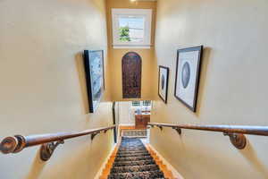 Stairway with wood finished floors and baseboards