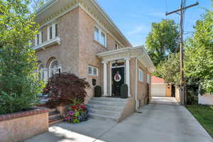 View of front of house featuring stucco siding, an outbuilding, and a garage