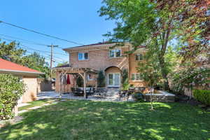 Rear view of property featuring a pergola, a patio, stucco siding, and french doors