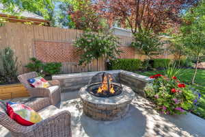 Fenced backyard featuring a fire pit and a patio