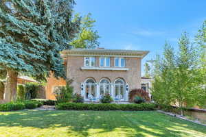 View of front facade featuring a front lawn and stucco siding