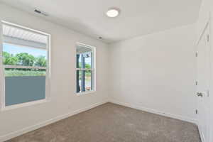 Carpeted empty room with baseboards