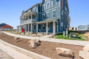 View of front of house featuring covered porch and a balcony
