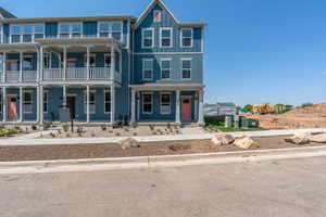 View of front facade featuring covered porch, a balcony, and board and batten siding