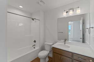 Bathroom featuring vanity,  shower combination, wood finished floors, and recessed lighting