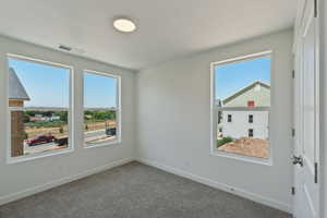Carpeted spare room with baseboards