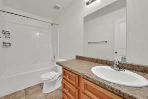 Full bath with vanity, bathtub / shower combination, and tile patterned flooring
