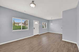 Foyer with baseboards and wood finished floors