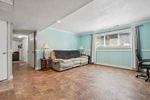 Living area featuring ornamental molding and a textured ceiling