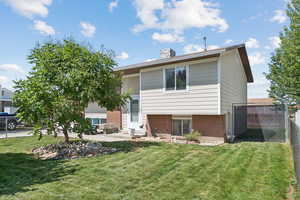 Back of property featuring brick siding, a patio, entry steps, and a chimney