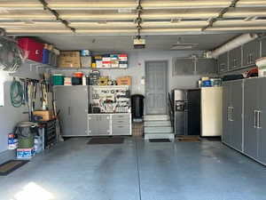Garage with black refrigerator with ice dispenser