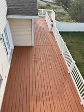 Wooden terrace with a fenced backyard
