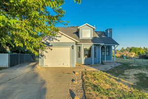 View of front of house with driveway, an attached garage, and a chimney