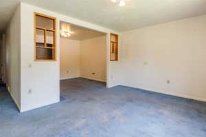 Carpeted spare room featuring baseboards