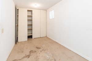 Unfurnished bedroom with unfinished concrete flooring and baseboards