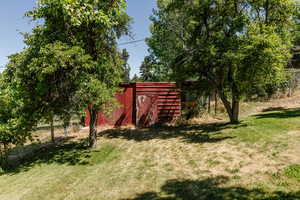 View of green lawn featuring an outbuilding