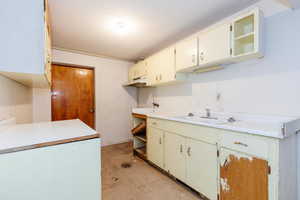 Kitchen with concrete flooring, light countertops, a textured ceiling, and refrigerator