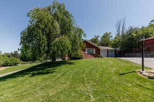 View of front of house featuring an attached garage, driveway, and brick siding