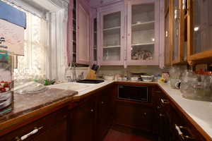 Kitchen with glass insert craftsman cabinets, light countertops