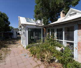 Side property featuring a sunroom and a chimney