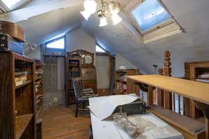 Loft with a skylight, hardwood / wood-style flooring