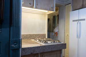 Kitchen with freestanding refrigerator and gas cooktop