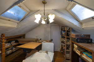 Loft with a skylight, hardwood / wood-style flooring