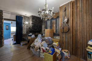 Large room with a chandelier and wood finished floors, featuring 1 of 4 fireplaces