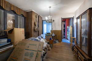 Large room with a chandelier and wood finished floors, featuring 1 of 4 fireplaces