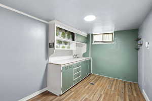 Bar with a sink and light wood finished floors