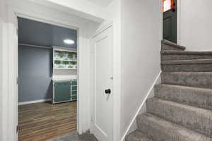 Stairway with wood finished floors and baseboards